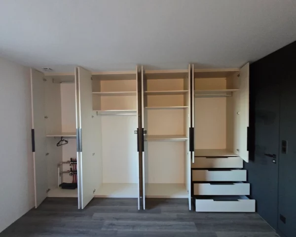 Dressing ouvert offrant de nombreux rangements avec penderies et tiroirs